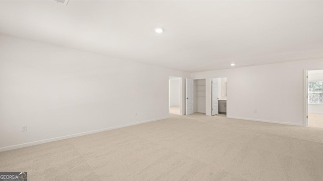 unfurnished room with baseboards and light colored carpet