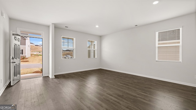 empty room with dark wood-type flooring and a healthy amount of sunlight