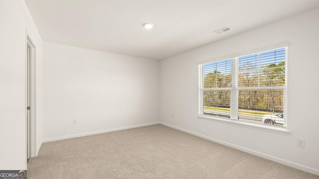 carpeted empty room featuring visible vents and baseboards