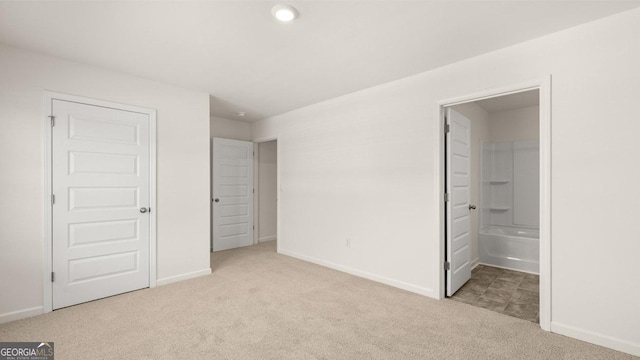 unfurnished bedroom with ensuite bathroom, baseboards, recessed lighting, and carpet floors