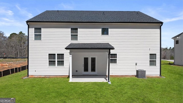 back of house with a patio area, a yard, and roof with shingles