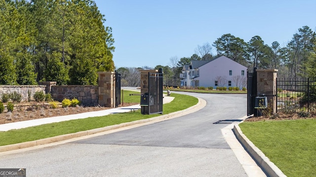 view of street featuring a residential view, curbs, and a gate