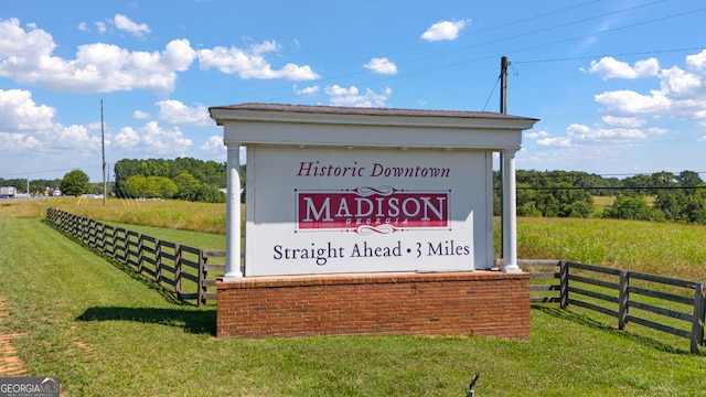 community sign with a lawn and a rural view