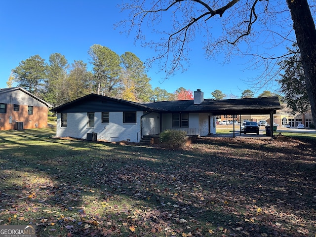 view of front of property with central AC unit, a front yard, and a carport