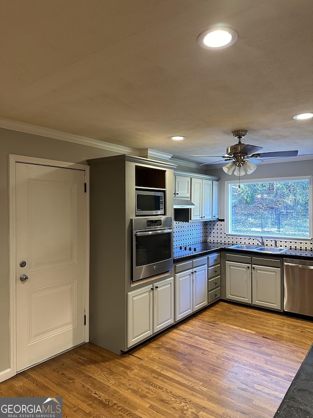 50 Pine Valley Dr, Athens, GA 30606 - kitchen with a ceiling fan, stainless steel appliances, dark countertops, light wood-style floors, and ornamental molding