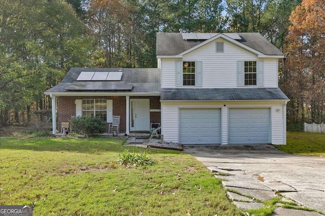 view of front facade with a front yard, solar panels, and a garage