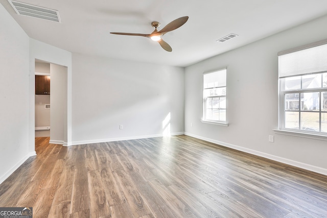 empty room with dark hardwood / wood-style floors and ceiling fan