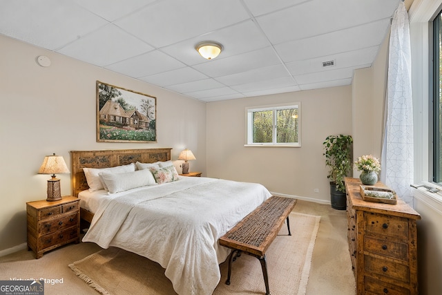 bedroom with baseboards, a paneled ceiling, visible vents, and light carpet