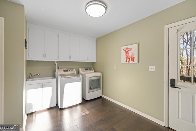 clothes washing area with baseboards, dark wood finished floors, washer and dryer, cabinet space, and a sink