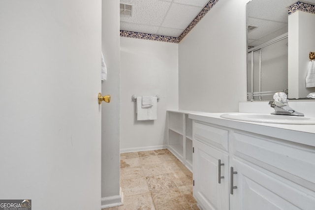 full bathroom featuring visible vents, a drop ceiling, a shower stall, baseboards, and vanity