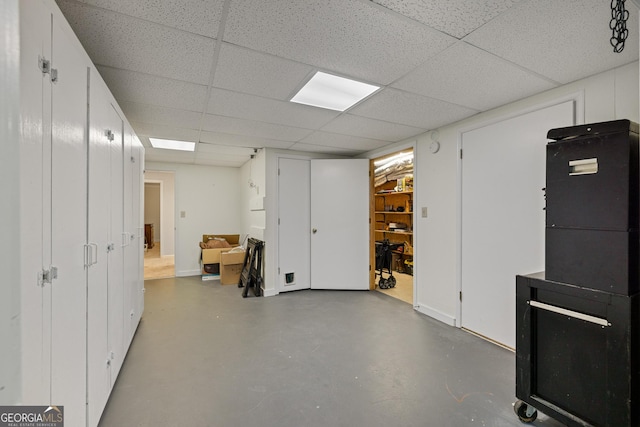 finished basement featuring baseboards and a paneled ceiling