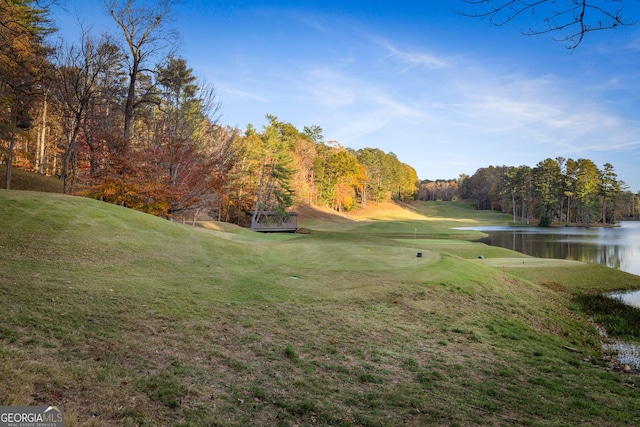 surrounding community with a yard, a water view, and golf course view