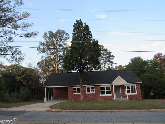 view of front of home with a front yard and a carport