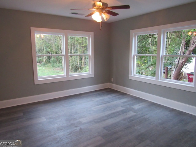 spare room with plenty of natural light, dark wood-type flooring, and ceiling fan