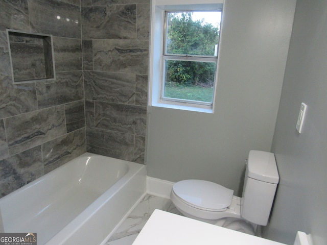 bathroom with tiled shower / bath and toilet