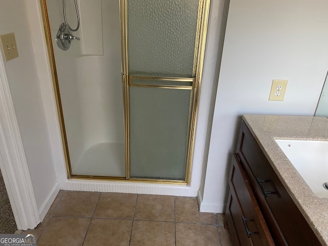 bathroom with tile patterned floors, a shower with door, and vanity