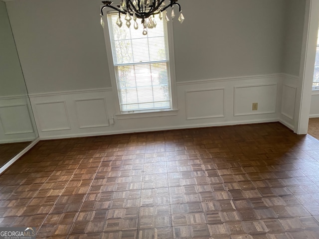 unfurnished dining area with a chandelier