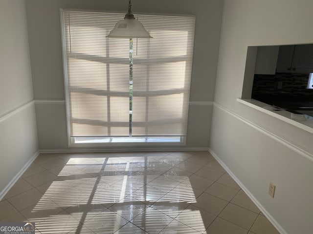 unfurnished dining area with light tile patterned flooring