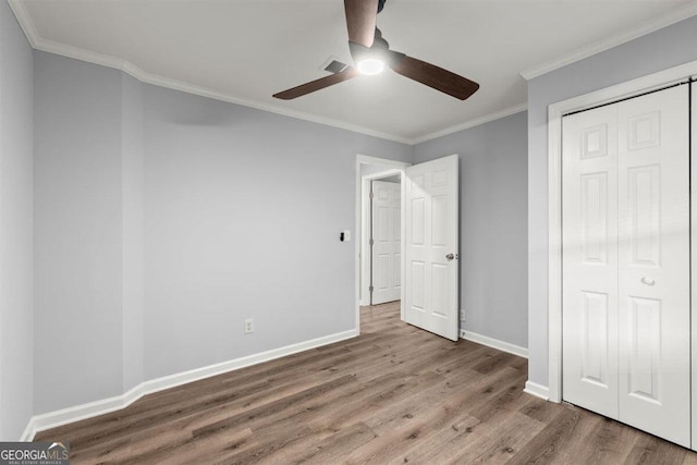 unfurnished bedroom featuring crown molding, ceiling fan, a closet, and hardwood / wood-style floors