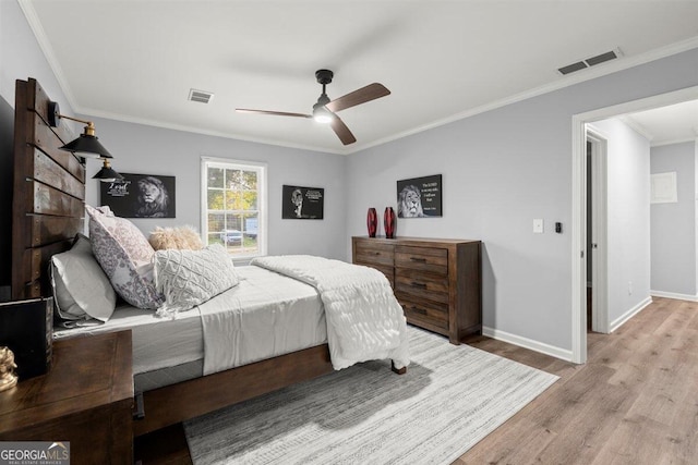 bedroom with ceiling fan, light hardwood / wood-style floors, and ornamental molding