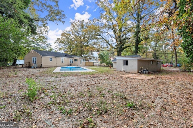 view of yard featuring an outbuilding and a fenced in pool