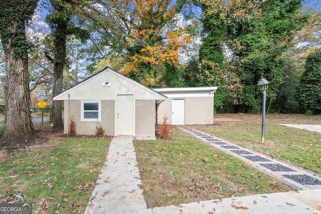 view of front facade with an outbuilding and a front lawn