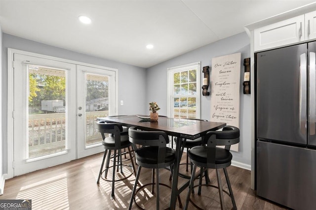 dining area with french doors, hardwood / wood-style flooring, and lofted ceiling