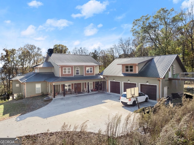 rear view of property with a porch and a garage