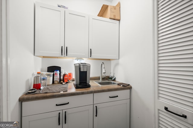 bar with white cabinets and sink