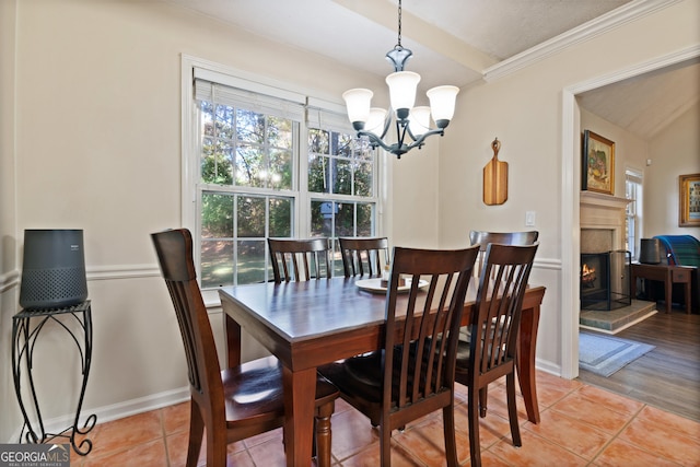 dining room with light hardwood / wood-style flooring, crown molding, and an inviting chandelier