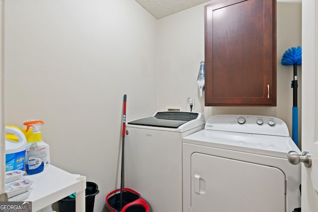 washroom featuring cabinets, a textured ceiling, and independent washer and dryer