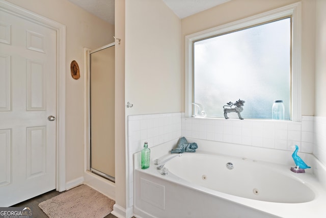 bathroom featuring plus walk in shower and a textured ceiling