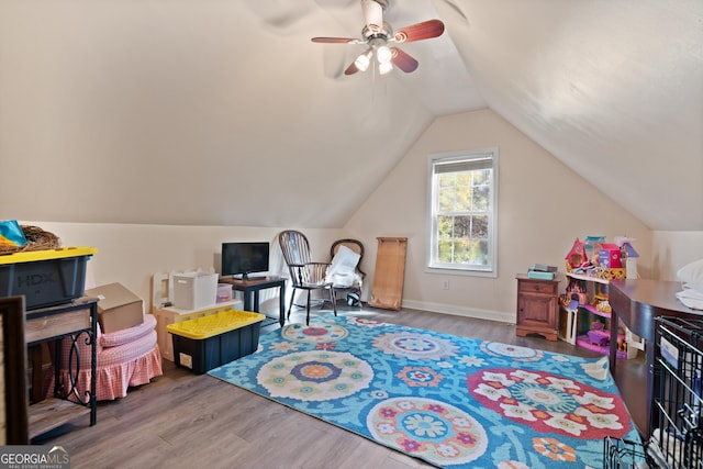 playroom with wood-type flooring, vaulted ceiling, and ceiling fan