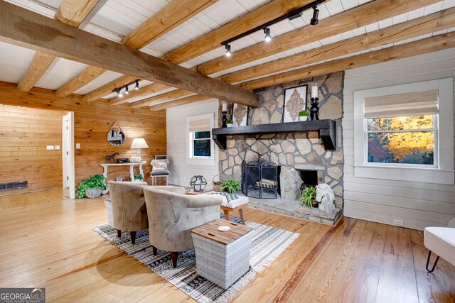 living room with a wealth of natural light, hardwood / wood-style floors, beamed ceiling, and track lighting