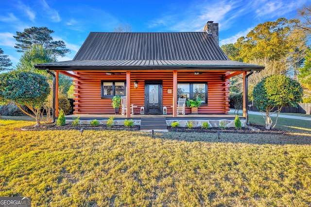 rear view of house featuring a lawn and covered porch