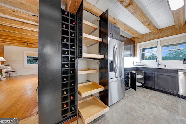 kitchen with wooden ceiling, stainless steel appliances, and a healthy amount of sunlight