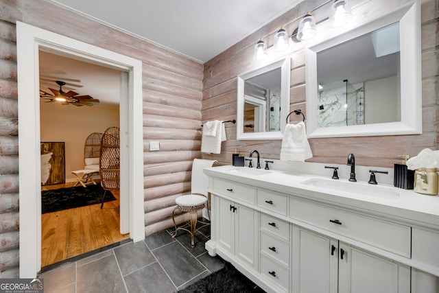 bathroom with rustic walls, ceiling fan, hardwood / wood-style floors, and vanity