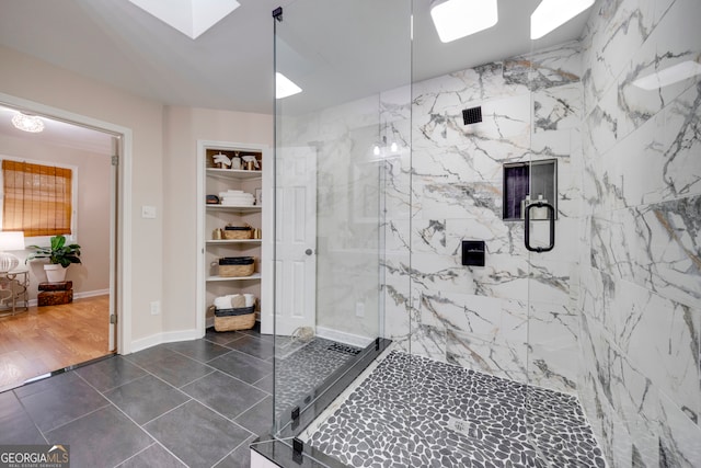 bathroom with a skylight, a shower with door, and hardwood / wood-style flooring