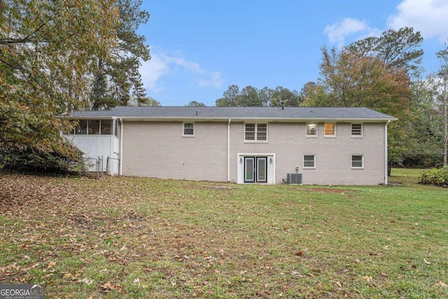 back of property with a lawn, a sunroom, and cooling unit