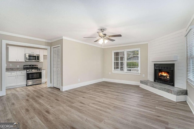 unfurnished living room with ceiling fan, ornamental molding, and light hardwood / wood-style flooring