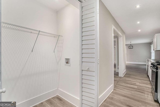 washroom with light hardwood / wood-style floors and washer hookup