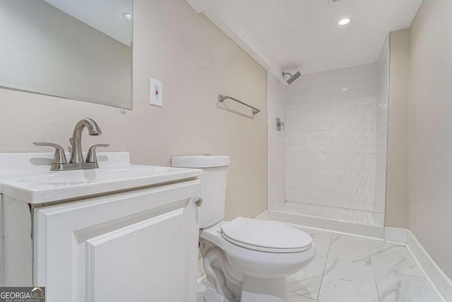 bathroom featuring tiled shower, vanity, and toilet