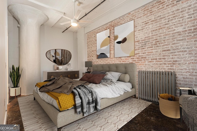 bedroom featuring radiator, ceiling fan, and brick wall