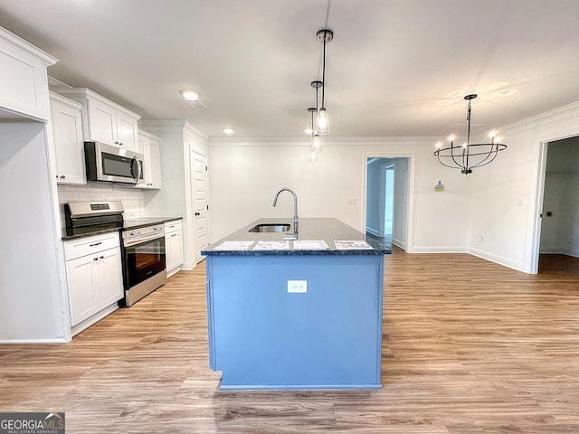 kitchen featuring a kitchen island with sink, white cabinets, light hardwood / wood-style flooring, decorative light fixtures, and stainless steel appliances