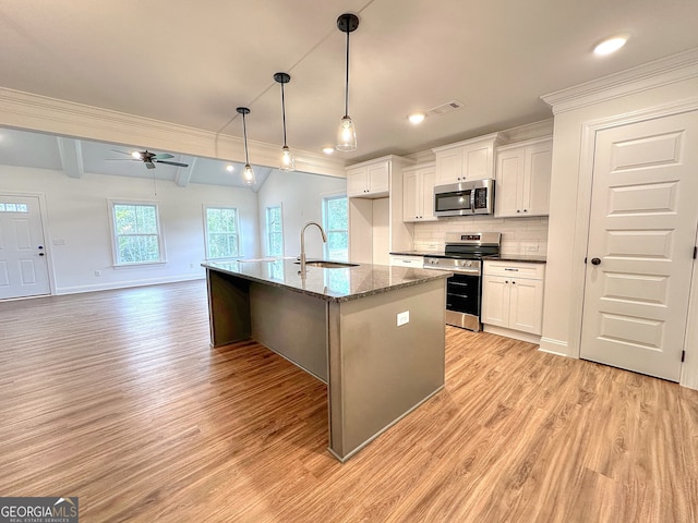 kitchen featuring white cabinetry, sink, light hardwood / wood-style floors, a center island with sink, and appliances with stainless steel finishes