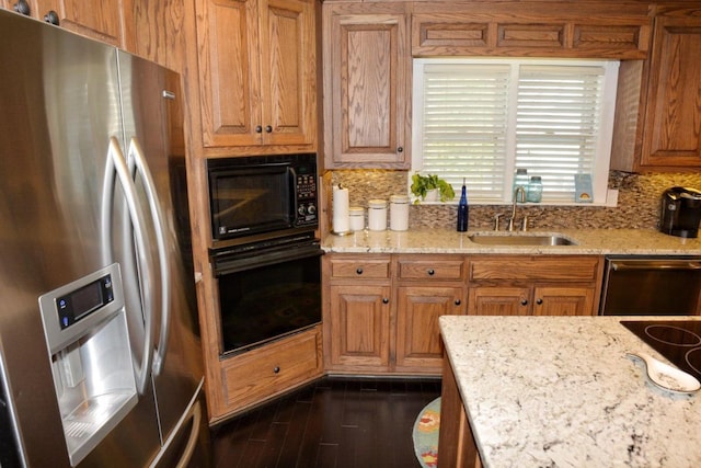 kitchen with backsplash, black appliances, sink, light stone countertops, and dark hardwood / wood-style flooring