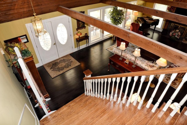 foyer with hardwood / wood-style floors, lofted ceiling, and a notable chandelier