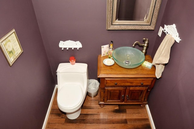 bathroom with wood-type flooring, vanity, and toilet