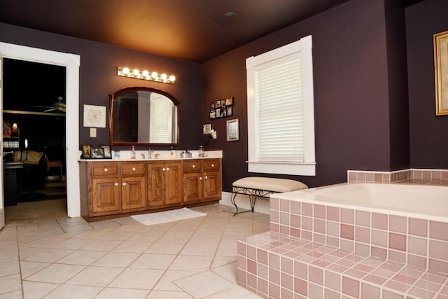 bathroom with ceiling fan, tile patterned flooring, vanity, and a relaxing tiled tub