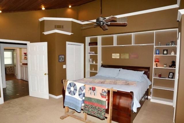 carpeted bedroom featuring ceiling fan, wood ceiling, a high ceiling, and a closet